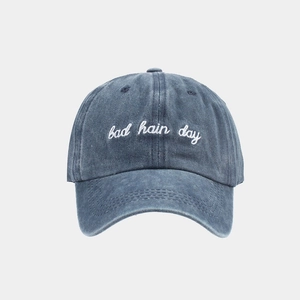 Detail of bad hair day embroidery on washed navy blue denim cotton baseball cap