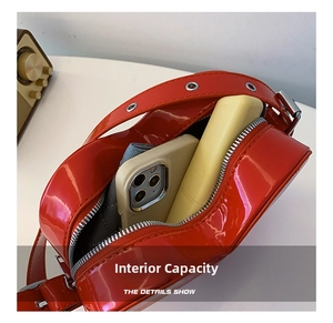Vue détaillée du sac bandoulière en cuir verni rouge montrant le compartiment intérieur