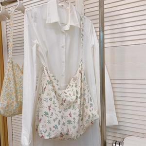 Detailed close-up of a floral cotton tote bag featuring colorful botanical and insect prints