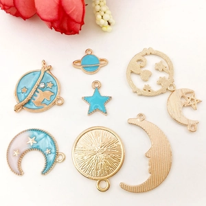 Detailed close-up of cosmic themed enamel charms including planets, stars and moons