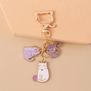 Detail of cute cat paw keychains with gold swivel clasps and purple-white cat charms