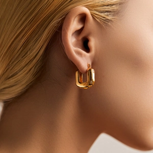 U-shaped gold plated earrings with sparkling star cubic zirconia on a female model