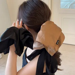 Elegant oversized satin bow hair scrunchies in black and brown with handmade label