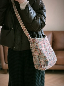 Detailed texture of colorful woven tweed crossbody bag with multi-color fiber pattern