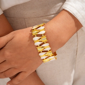 Dettaglio del bracciale vintage a catena dorata con petali in smalto bianco e zirconi