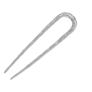 Detail of silver metal U-shaped hair pin featuring a textured hammered finish surface