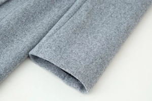 Close-up of gray wool coat sleeve showing high-quality fabric texture and stitching detail