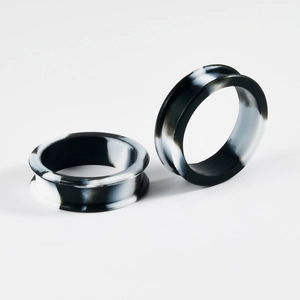 Detailed view of hollow black and white marble pattern silicone ear gauges