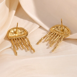 Vue détaillée des boucles d'oreilles méduse en plaqué or 18K sur un tissu en soie