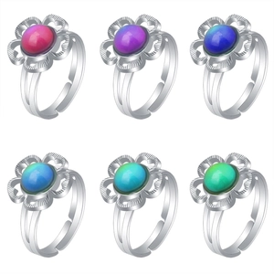 Detail of color-changing gemstone rings showing spectrum of hues in floral silver bands