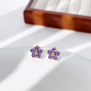 Exquisite gold floral stud earrings with purple crystal petals and gold bead center