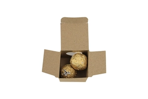 Detail of kraft paper gift box with heart window and gold foil chocolates inside