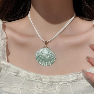 Detail of teal gradient shell pendant necklace on model with elegant choker style