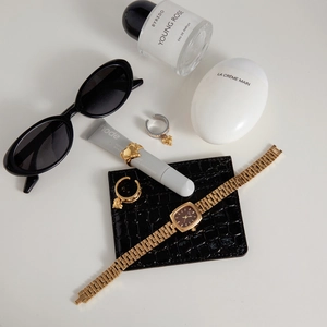 Nature morte de bagues cœur et montre dorée avec des accessoires de luxe chic
