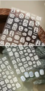 Detailed macro view of 5D white embossed Christmas nail art stickers featuring snowmen