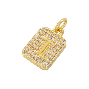 Detailed macro view of gold-plated square pendant with pavé cubic zirconia and letter T