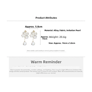 Detail view of long floral earrings with fabric petals and pearls measuring 14cm by 5.8cm