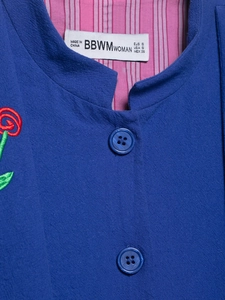 Close-up of royal blue jacket with rose embroidery and pink striped lining