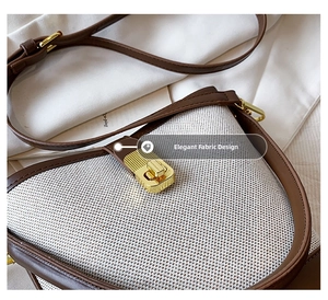 Detail of woven fabric handbag featuring brown leather trim and a golden metal twist lock