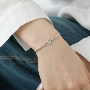 Close-up of S925 sterling silver tennis bracelet with cubic zirconia evil eye charm