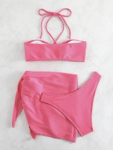 Detailed view of pink ribbed bikini set with halter top and matching sarong skirt