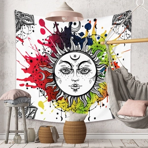 Detail of bohemian sun tapestry with colorful splatter art in a cozy interior setting