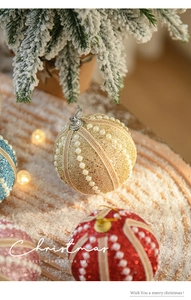 Detail of glitter Christmas foam balls with pearls on a snowy wood surface