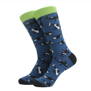 Mid-calf knitted socks featuring navy orca whale patterns and green ribbed cuffs
