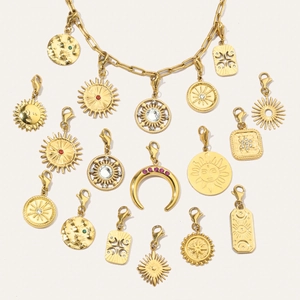 Macro view of gold celestial pendants with sun and moon motifs and colored zircons