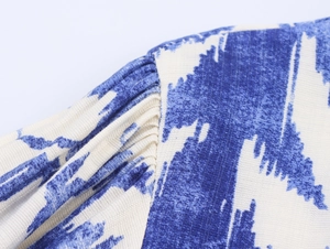 Macro shot of pleated shoulder detail on blue and white printed long dress