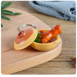 Détail macro d'un porte-clés miniature réaliste avec poulet et poivrons verts