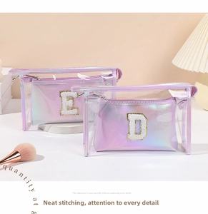 Dettaglio della pochette laser viola e borsa in PVC con toppe con lettere E e D dorate