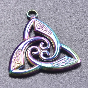 Macro shot of iridescent rainbow stainless steel witch knot pendant with triquetra detail