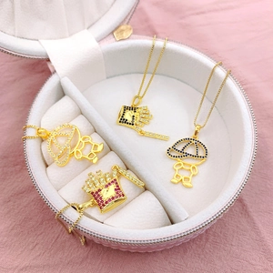 Vue macro détaillée de pendentifs frites et garçon plaqués or avec des zircons brillants