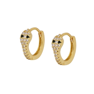 Detailed macro view of golden snake-shaped earrings with black and white zircon stones