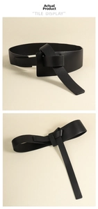 Detailed view of black wide leather waist belt featuring a minimalist knot design closure