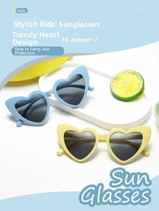Detailed view of heart-shaped kids sunglasses in blue and yellow on summer tray