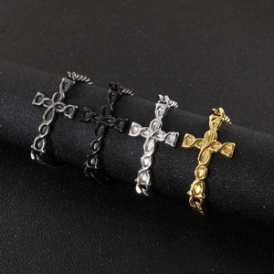 Cross pendant necklaces in black, silver, and gold finishes displayed on a round stand