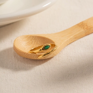 Französischer Vintage Gold Schlangenring mit grünem Stein auf Holzlöffel Dekor