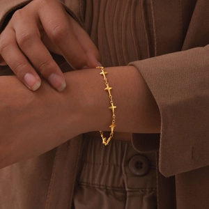 Minimalist gold stainless steel star chain bracelet for women on model's wrist