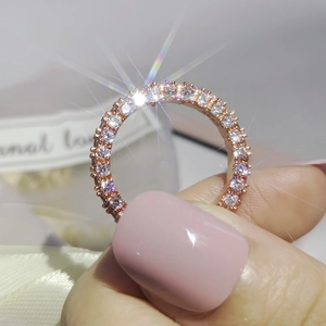 Close-up of rose gold ring with three-sided zircon pavé and eternal love ribbon