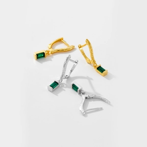 Close-up of S925 sterling silver earrings with textured finish and green gemstone pendants