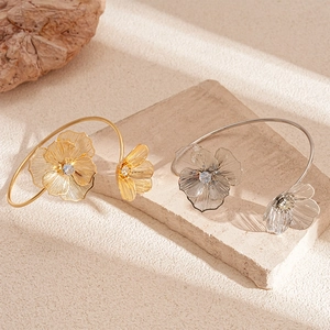 Bracelet jonc ouvert fleur avec zircons sur fond de pierre doré et argenté