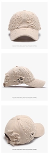 Close-up of distressed beige baseball cap with frayed edge details and washed cotton texture