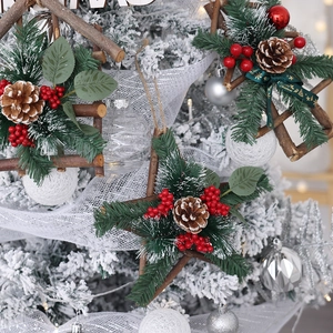 Star-shaped Christmas wreaths with pine needles and red berries on a snowy tree