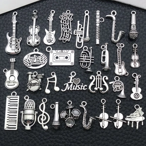 28pcs silver musical instrument charms including guitar, violin, and notes on black background