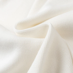 Macro detail of high-quality white ribbed knit fabric texture showing softness and drape