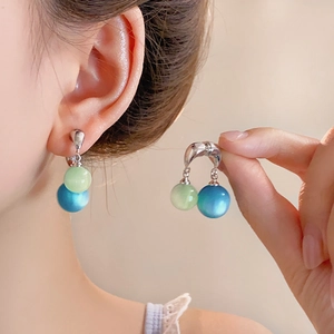 Orecchini in argento con perle occhio di gatto blu mare e verde chiaro su modella