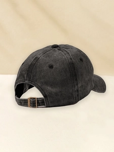 Detail of adjustable metal buckle and vintage washed fabric texture on baseball cap