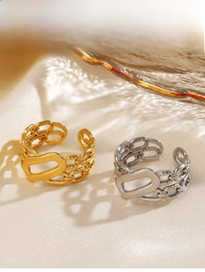 Close-up of gold and silver chain link rings with oval plates on a silk background